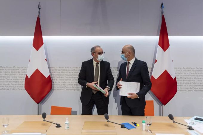 Bundesratspräsident Guy Parmelin, links, diskutiert mit Bundesrat Alain Berset nach einer Medienkonferenz über die neusten Massnahmen zur Bewältigung der Krise um die Pandemie des Coronavirus. CORONAVIRUS Bundesrat