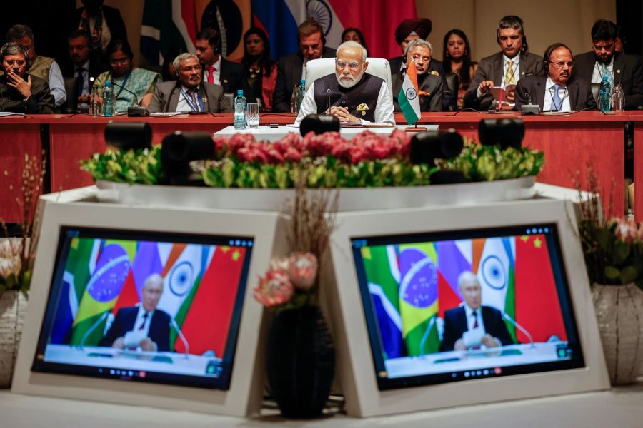 Indiens Premierminister Narendra Modi (M) schaut der Plenarsitzung auf dem Brics-Gipfel 2023 zu, während Kremlchef Wladimir Putin per Videoübertragung spricht.