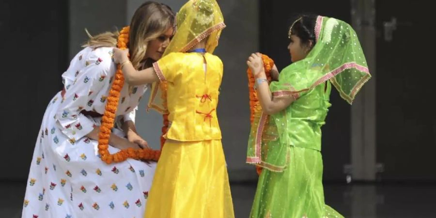 Melania Trump wird von zwei Kindern an der Sarvodaya Co-Educational Senior Secondary School begrüsst. Foto: Altaf Qadri/AP/dpa