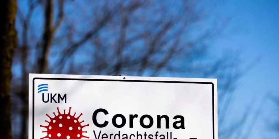 Ein Hinweisschild mit der Aufschrift «Corona Verdachtsfall-Anlaufstelle» steht vor der Uniklinik Münster. Foto: Rolf Vennenbernd/dpa