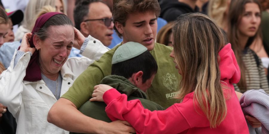 Familienangehörige eines Opfers der Schießerei vom Sonntag trauern an einem Blumendenkmal, das nach dem Anschlag am Bondi Pavilion am Bondi Beach in Sydney, Australien, errichtet wurd...
