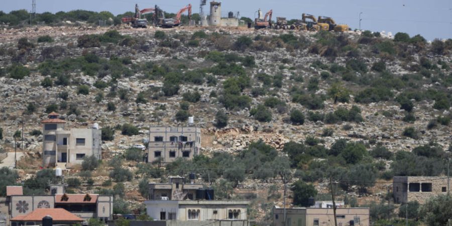 ARCHIV - Bulldozer arbeiten an einem israelischen Siedler-Außenposten im Westjordanland. Foto: Nasser Nasser/AP/dpa/Archivbild