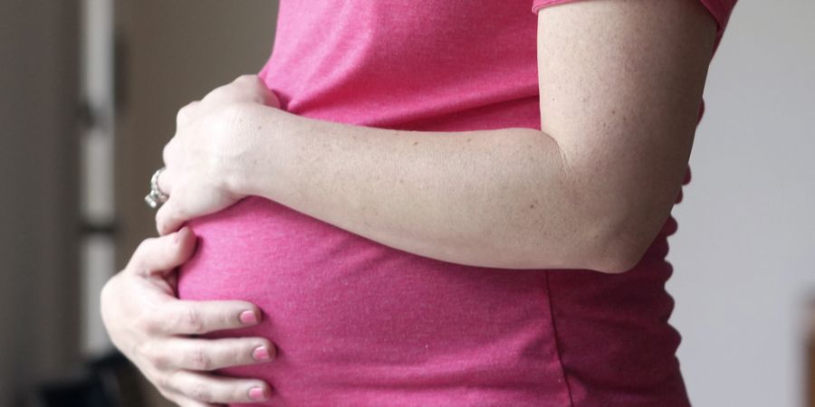 Schwangere Frau hält Bauch