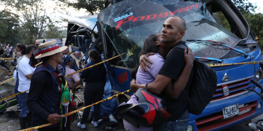 dpatopbilder - Angehörige von Opfern umarmen sich vor einem Bus, der von einem Sprengsatz zerstört wurde. Foto: Santiago Saldarriaga/AP/dpa