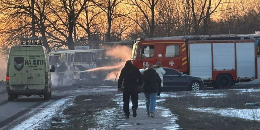 HANDOUT - Feuerwehrleute löschen das Feuer, nachdem eine russische Kampfdrohne einen mit Grubenarbeitern besetzten Bus getroffen hatte. Mindestens 15 Menschen wurden getötet. Foto: Un...