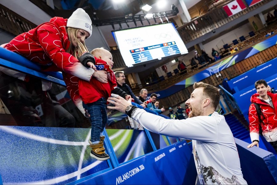 Briar Schwaller-Hürlimann reicht Bronze-Gewinner Yannick Schwaller den gemeinsamen Sohn River aufs Eis.