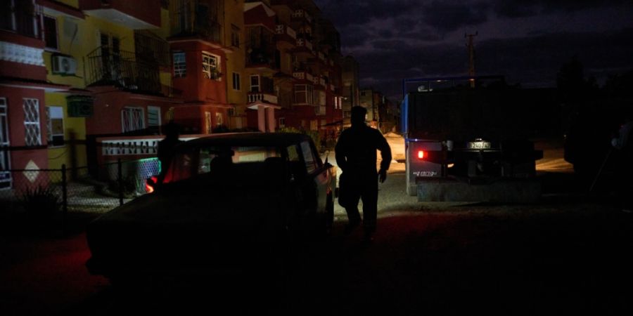 ARCHIV - Ein Mann geht im Dunkeln während eines geplanten Stromausfalls im Rahmen der Energierationierung in Santa Cruz del Norte, wo sich eines der größten thermoelektrischen Kraftw...