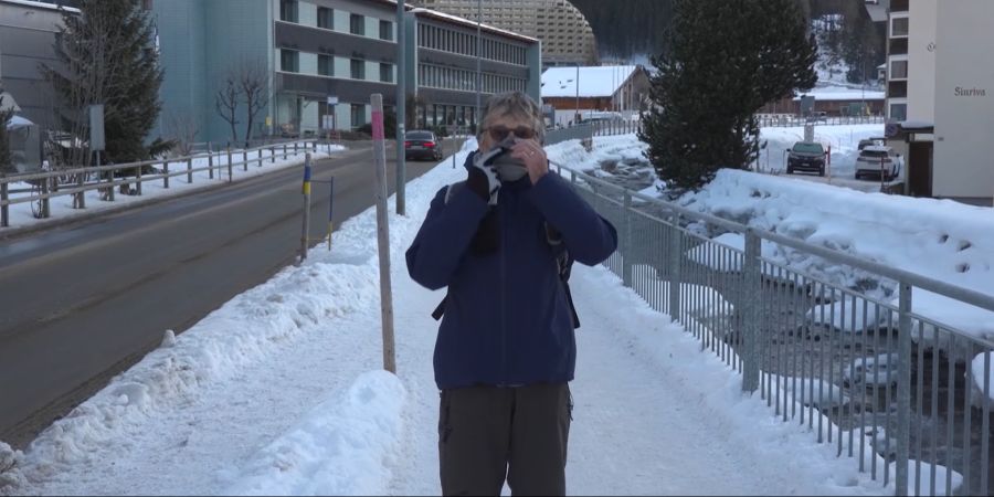 Margrit (74) hält sich den Schaal vor Mund und Nase. Es stinke wegen den Autos und vor allem den Helikoptern.