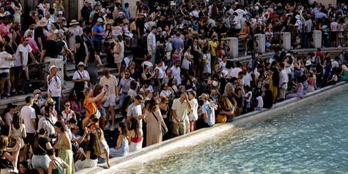 Touristen kühlen sich am Brunnen in Trevi ab. hitze südeuropa
