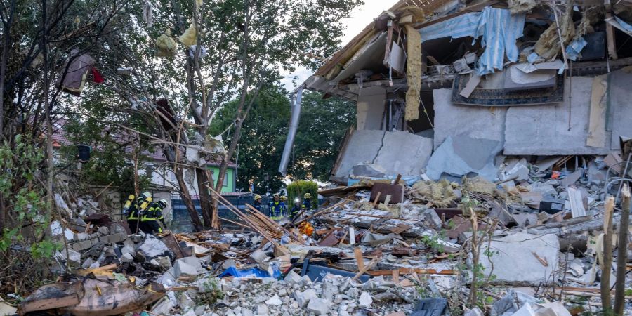 Rettungskräfte arbeiten nach der Explosion eines Reiheneckhauses in Memmingen an der Unglücksstelle.