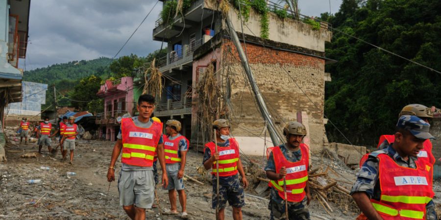 Arbeiter räumen nach einer Sturzflut im Gebiet Devighat im Distrikt Nuwakot Trümmer weg. Foto: Rajesh Kumar Singh/AP/dpa
