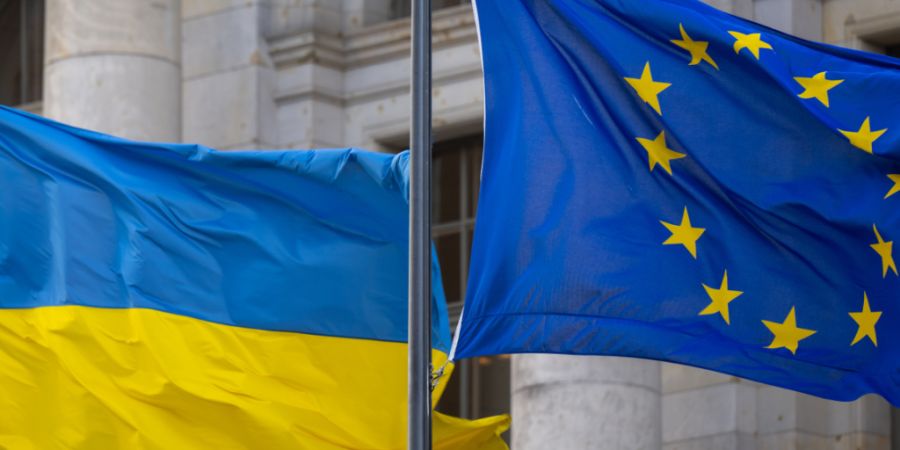 ARCHIV - Die Nationalflagge der Ukraine und die Flagge der EU wehen im Wind. Foto: Monika Skolimowska/dpa