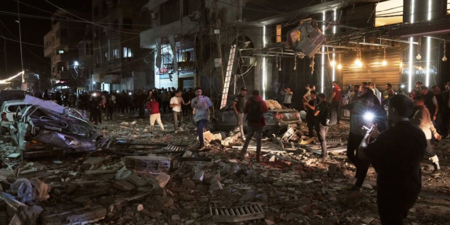 dpatopbilder - Palästinenser inspizieren den Ort eines israelischen Luftangriffs. Foto: Jehad Alshrafi/AP/dpa