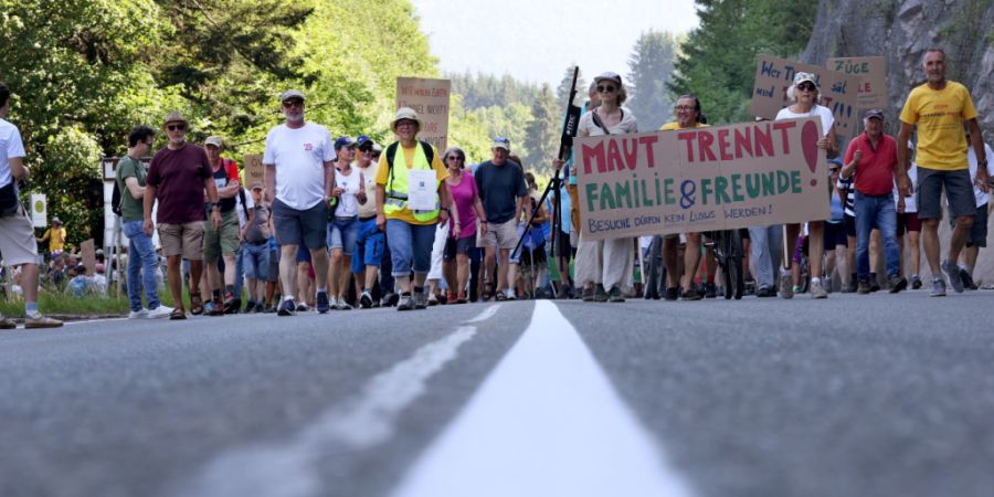 dpatopbilder - Demonstranten mit einem Schild auf dem «Maut trennt, Familie  Freunde, Besuche dürfen kein Luxus werden!» zu lesen ist, ziehen in einem Demonstrationszug auf der gesperr...