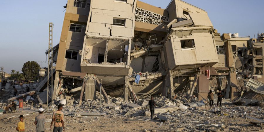 ARCHIV - Palästinenser inspizieren ihre Häuser, nachdem sie durch israelischen Beschuss östlich von Deir al-Balah zerstört wurden. Foto: Abdel Kareem Hana/AP/dpa