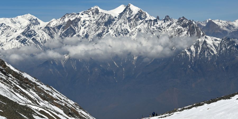 PRODUKTION - Schneebedeckte Berggipfel des Himalaya ragen über einer Wolkenschicht auf. Foto: Elisa Schu/dpa/Symbolbild