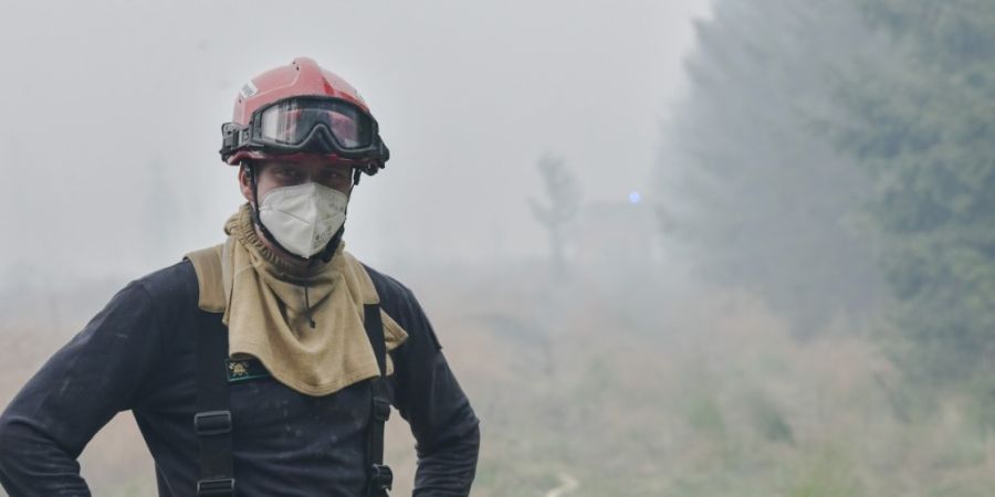 dpatopbilder - Ein Feuerwehrmann im Waldbrandgebiet. Im Naturschutzgebiet Hohes Venn nahe der deutschen Grenze wütet ein Großbrand. Foto: Nicolas Lambert