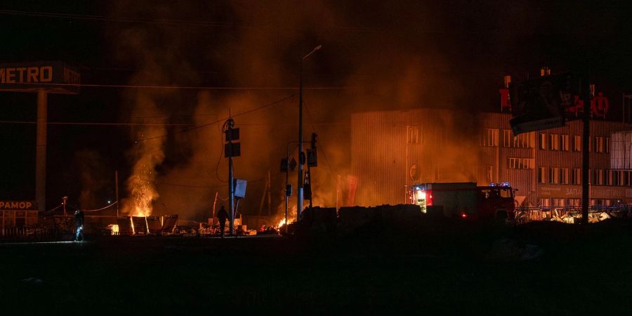 Rettungskräfte löschen das Feuer in Charkiw.