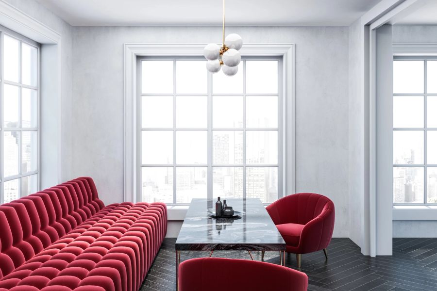 Ein auffälliges rotes Sofa, das den schlichten Innenraum wunderschön hervorhebt.