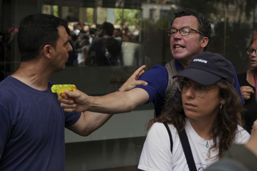 Ein nicht uniformierter Polizist (l.) versucht einen Demonstranten auf den Strassen Barcelonas zu beruhigen.