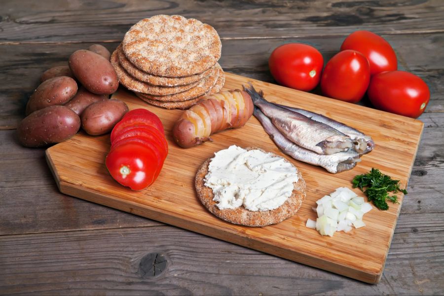 Hering mit Tomaten auf Schneidebrett