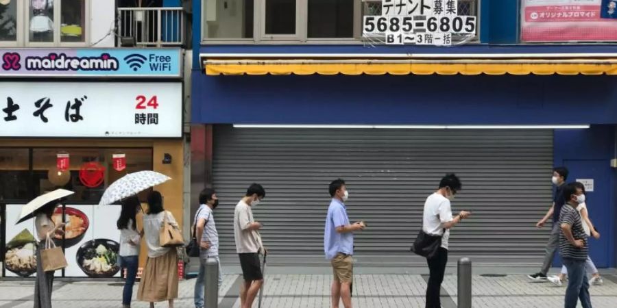 In der japanischen Hauptstadt Tokio warten Menschen in einer Schlange auf einen PCR-Test. Foto: Marijan Murat/dpa