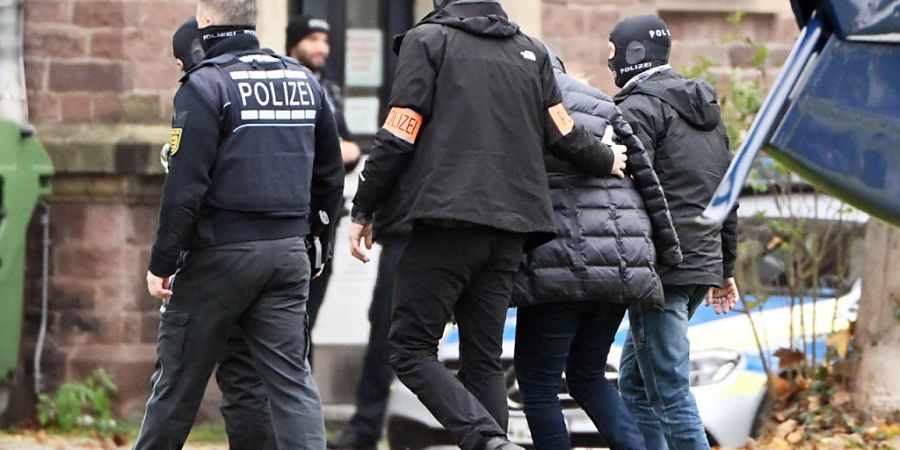 ARCHIV - Eine Person (2.v.r.) wird von Polizisten in Karlsruhe aus einem Hubschrauber gebracht. Die deutsche Bundesanwaltschaft hat nach der grossangelegten Anti-Terror-Razzia gegen sogenannte Reichsbürger vor rund einem Jahr erstmals Anklage erhoben. Foto: Uli Deck/dpa