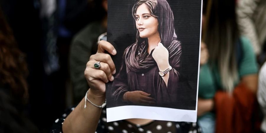 Protestierende mit Foto von Mahsa Amini