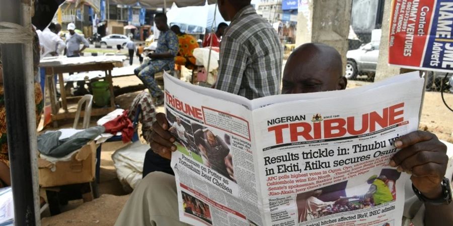 Verkäufer liest am Montag Zeitung in Lagos