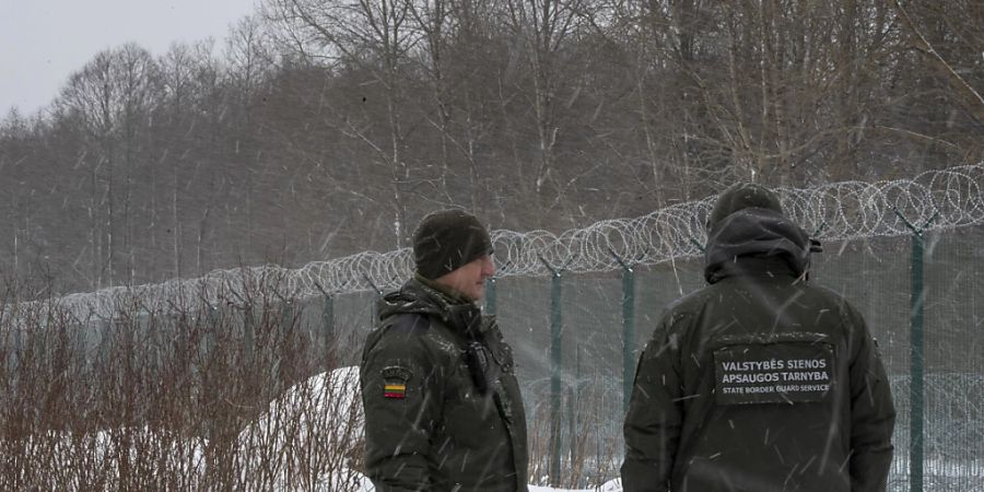 ARCHIV - Mitglieder des litauischen Grenzschutzdienstes stehen an der Grenze zu Belarus. Foto: Mindaugas Kulbis/AP/dpa