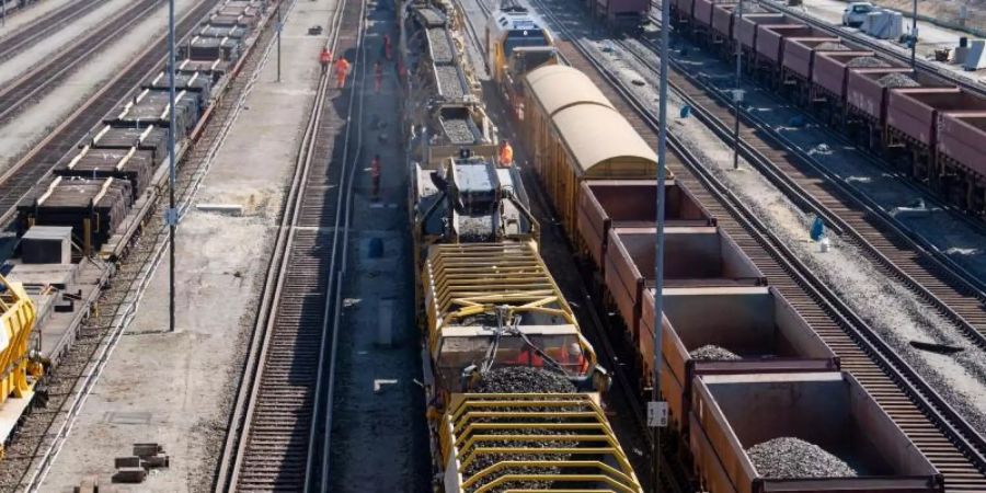 Güterzüge und ein Zug für die Untergrundsanierung von Bahnstrecken stehen auf den Gleisen am Rangierbahnhof München-Nord. Foto: Sven Hoppe/dpa