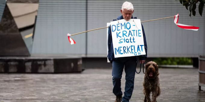 «Demokratie statt Merkelatur·» steht auf einem Schild eines Teilnehmers einer Demonstration gegen Corona-Beschränkungen. Coronavirus - Demonstration gegen Corona-Massnahmen