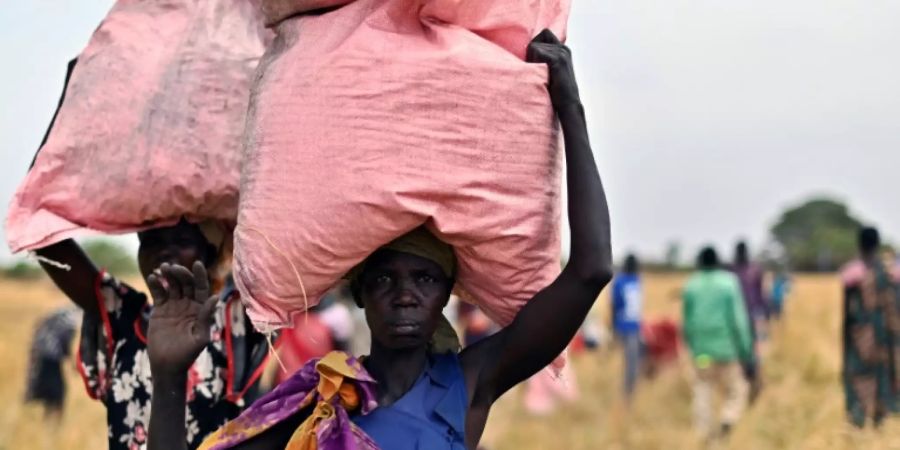 Dorfbewohner im Südsudan mit Hilfsgütern