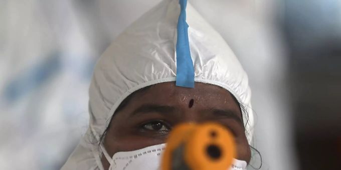 Eine medizinische Mitarbeiterin überprüft im indischen Mumbai die Temperatur einer Frau. Foto: Rafiq Maqbool/AP/dpa Eine medizinische Mitarbeiterin überprüft im indischen Mumbai die Temperatur einer Frau. Foto: Rafiq Maqbool/AP/dpa