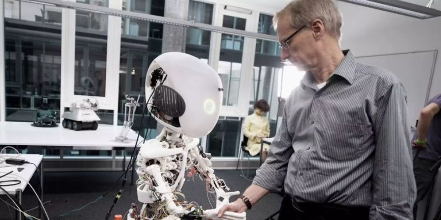 Schon vor sieben Jahren schüttelte Professor Dr. Rolf Pfeifer, Direktor des Artificial Intelligence Laboratory der Universität Zürich, dem von seinem Institut entwickelten Roboter ROBOY die Hand. Mittlerweile ist Künstliche Intelligenz ein elementarer Wirtschaftsfaktor. Zeit, dass die Politik einen Rahmen dafür liefere, beispielsweise ethischer Art, sagen Experten. (Archivbild)