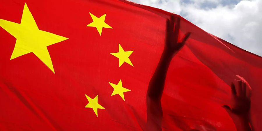 dpatopbilder - Ein China-Anhänger hält eine chinesische Nationalflagge während einer Kundgebung zur Feier der Verabschiedung eines nationalen Sicherheitsgesetzes für Hongkong. Ungeachtet weltweiter Kritik hat China nach Medienberichten das kontroverse Gesetz zum Schutz der nationalen Sicherheit in Hongkong erlassen. Foto: Kin Cheung/AP/dpa