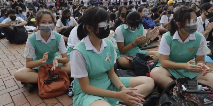 Sekundarschülerinnen und -schüler sitzen während eines Protests in Hongkong am Boden. Hongkong