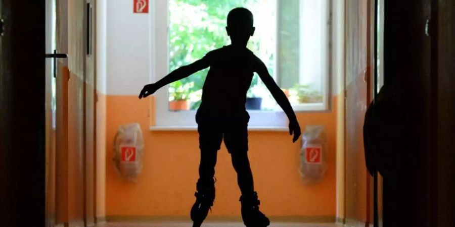 Ein Junge fährt auf dem Flur des Diakonischen Werkes mit seinen Skates. Foto: Ralf Hirschberger/ZB/Illustration