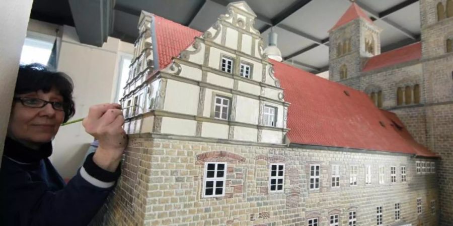In der Projektwerkstatt «Kleiner Harz» wird ein Modell der Quedlinburger Stiftskirche bemalt. Das Modell kann zusammen mit anderen Sehenswürdigkeiten aus dem Harz ab dem 16. April in Wernigerode bestaunt werden. Foto: Matthias Bein