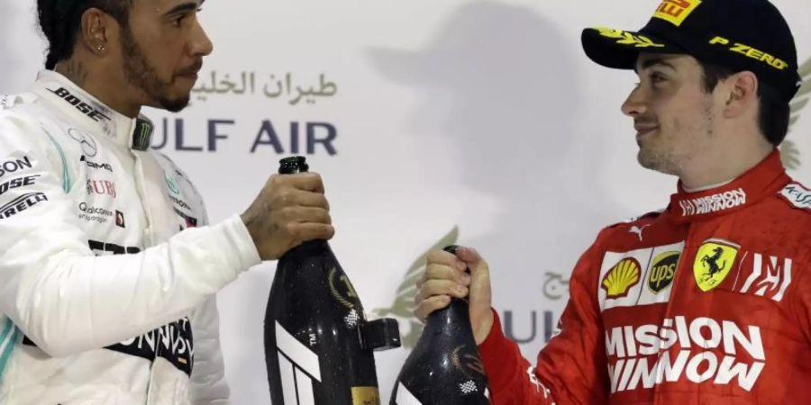 Auf dem Podest in Bahrain: Sieger Lewis Hamilton (l) und der Drittplatzierte Charles Leclerc. Foto: Luca Bruno/AP/dpa