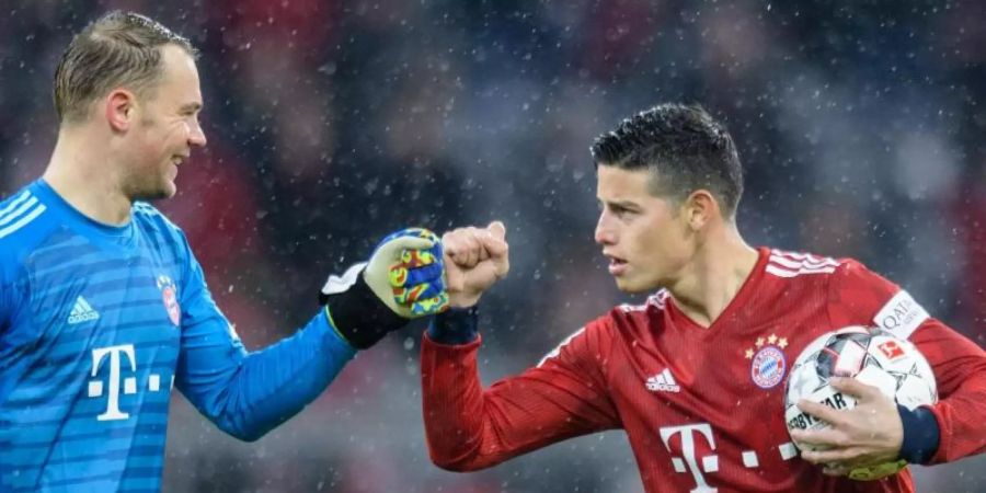 Dreifachtorschütze James Rodríguez (r) feiert mit Torwart Manuel Neuer den Sieg des FC Bayern München. Foto: Matthias Balk