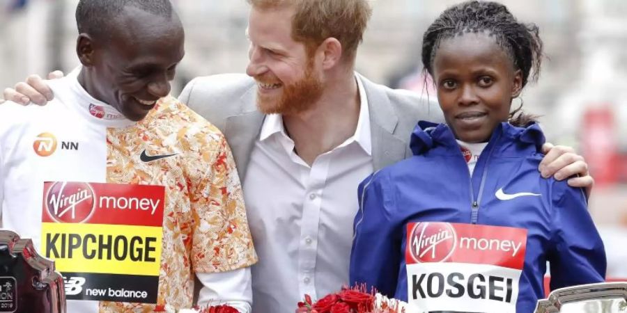 Der Kenianer Eliud Kipchoge hat zum vierten Mal den London-Marathon gewonnen. Bei den Frauen setzte sich die Kenianerin Brigid Kosgei. Prinz Harry freut sich mit den beiden. Foto: Alastair Grant/AP