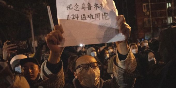 Ein Mann protestiert in Peking gegen die Kommunistische Partei und deren strikten Covid-Massnahmen, 27. November 2022. Auf seinem Blatt Papier steht «Gedenken den am 24. November in Urumtschi verstorbenen Mitbürgern». China Proteste Peking Urumtschi