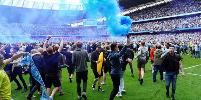 Fans von Manchester City stürmen das Spielfeld und jubeln über den Gewinn der englischen Meisterschaft. Fans von Manchester City stürmen das Spielfeld und jubeln über den Gewinn der englischen Meisterschaft.