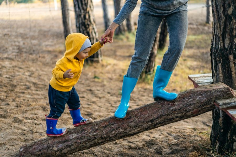 Baum Kind balancieren Mutter Gummistiefel Wald Stamm