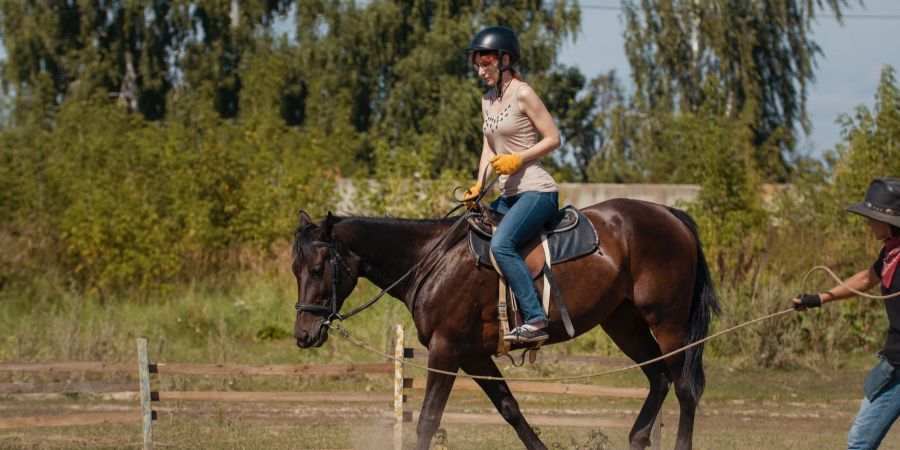 Frau auf Pferd Reitunterricht