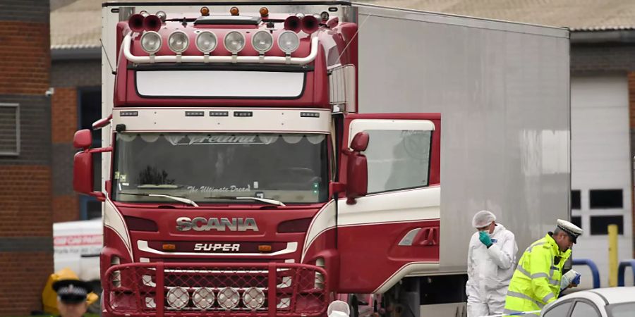 ARCHIV - Polizisten und Mitarbeiter der Spurensicherung arbeiten an dem LKW, in dem 39 Leichen gefunden wurden. Foto: Stefan Rousseau/PA Wire/dpa