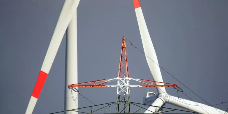 Bei den Energiekosten ist für die Haushalte in Deutschland keine Entlastung in Sicht - obwohl der Bund viele Milliarden Euro in die Deckelung der EEG-Umlage steckt. Windräder und ein Strommast in Erkelenz. Foto: David Young/dpa