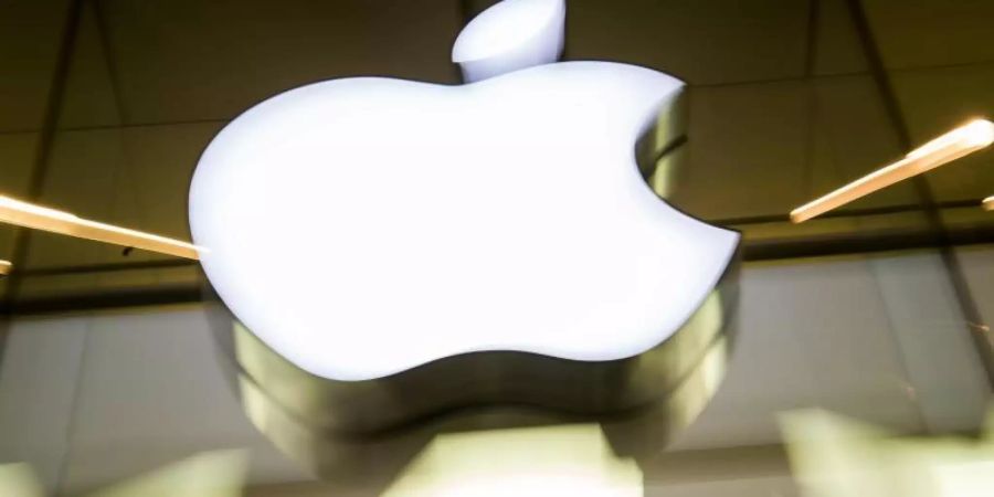 Das Apple-Logo leuchtet an der Fassade des Apple-Store. Foto: picture alliance / Peter Kneffel/dpa