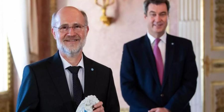 Markus Söder (r, CSU) hat Harald Lesch für sein Lebenswerk ausgezeichnet. Foto: Sven Hoppe/dpa